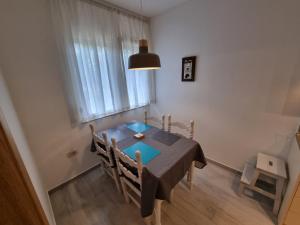 a dining room with a blue table and a window at Golden Fields Apartment near the Old Town in Kotor +7 photos