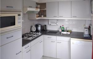 cocina blanca con fogones y microondas en 3 Bedroom Nice Home In Vlagtwedde, en Vlagtwedde