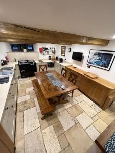 a large kitchen with a wooden table in it at The Horners - Log burner, Cheshire Village, Parking, Walks, Aga, dogs in Prestbury