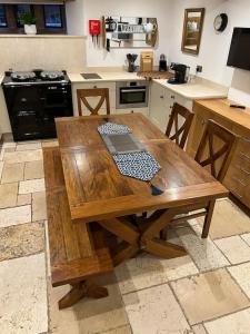 uma cozinha com uma mesa de madeira em The Horners - Log burner, Cheshire Village, Parking, Walks, Aga, dogs em Prestbury