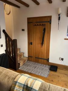 1 dormitorio con puerta de madera y escalera en The Horners - Log burner, Cheshire Village, Parking, Walks, Aga, dogs en Prestbury