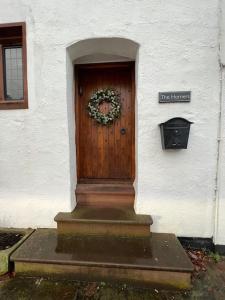 uma porta da frente de uma casa com uma coroa de flores em The Horners - Log burner, Cheshire Village, Parking, Walks, Aga, dogs em Prestbury