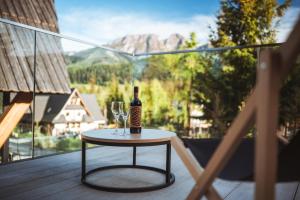 een fles wijn en een glas op een tafel op een balkon bij VIP Chalet ZAKOPANE in Kościelisko