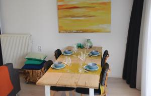 uma mesa de madeira com cadeiras e copos de vinho em Gorgeous Home In Julianadorp With Kitchen em Julianadorp