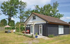 ein kleines schwarzes Cottage mit einer Veranda und einer Terrasse in der Unterkunft 2 Bedroom Lovely Home In Julianadorp in Julianadorp