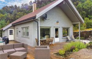 ein Haus mit einer Terrasse mit einem Tisch und Stühlen in der Unterkunft Stunning Home In Hebnes With Kitchen in Hebnes