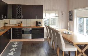 una cucina con tavolo in legno con sedie e una sala da pranzo di Stunning Home In Hebnes With Kitchen a Hebnes