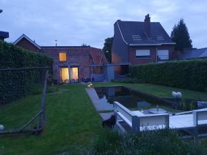 une maison avec un étang dans la cour dans l'établissement Gezellige moderne woning met zwemvijver, à Halle