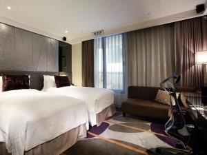 een hotelkamer met 2 bedden en een bank bij The Tango Hotel Taipei ChangAn in Taipei