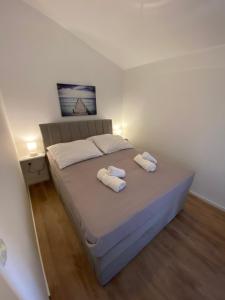 - une chambre avec un lit et 2 serviettes dans l'établissement Apartments Mima, à Petrčane
