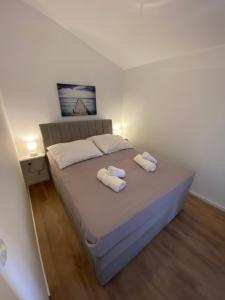 een slaapkamer met een bed met twee handdoeken erop bij Apartments Mima in Petrcane +50 foto's