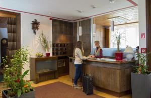 two women standing at a counter in a kitchen at Hotel Jägerhaus in Titisee-Neustadt