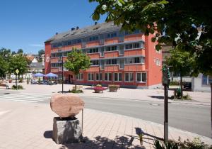 ein Gebäude an der Seite einer Straße mit einer Statue in der Unterkunft Hotel Jägerhaus in Titisee-Neustadt