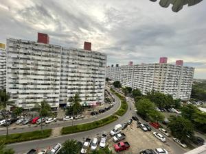 two large white buildings in a parking lot with cars at Popular Condo เมืองทองธานี in Pak Kret