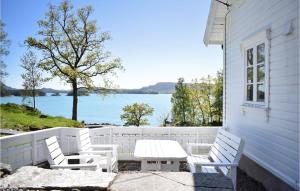 Valevågにある3 Bedroom Amazing Home In Valevgのテーブルと椅子が備わるポーチ(水辺の景色を望む)