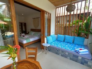 Coco Cabana في غيلي تراوانغان: غرفة مع شرفة مع أريكة وسرير
