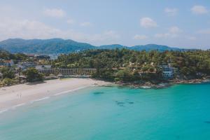 a beach with palm trees and palm trees at Beyond Resort Karon - SHA Extra Plus in Karon Beach