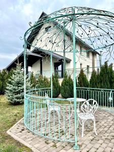 una mesa y sillas bajo una sombrilla frente a una casa en Waincris spa, en Stolniceni-Prăjescu
