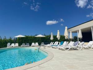a swimming pool with lounge chairs and umbrellas at Green Oasis in Stolniceni-Prăjescu