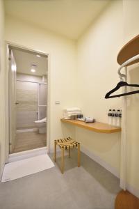 ein Badezimmer mit einem Waschbecken, einer Bank und einer Dusche in der Unterkunft 千晴包棟民宿 in Taitung