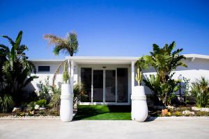 玛格丽塔萨沃亚AURORA BEACH & SUITE的一座白色的房子，前面有棕榈树