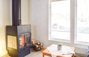 a fireplace in a living room with a window at Two-Bedroom Holiday Home In Ingaro in Grönskan