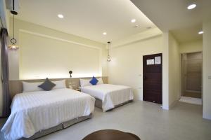 台東市的住宿－千晴民宿，一间卧室配有两张带白色床单的床