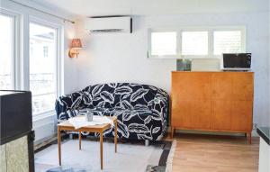 a living room with a couch and a table at Two-Bedroom Holiday Home In Ingaro in Grönskan