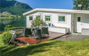 una casa pequeña con una mesa y sillas en una terraza en Awesome Home In Malmefjorden With Kitchen en Sylte