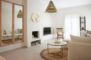 a living room with a white couch and a mirror at Spiliada Private House Batsi in Batsi