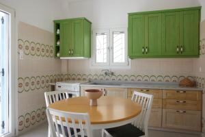 a kitchen with green cabinets and a wooden table at Spiliada Private House Batsi in Batsi +7 photos