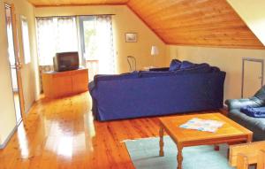 5 Bedroom Awesome Home In Strngns في Aspö: غرفة معيشة مع أريكة زرقاء وطاولة