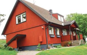 a red house with a black roof at Cozy Home In Strängnäs With Sauna in Aspö