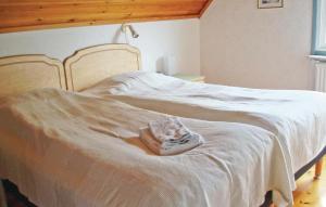 un letto con lenzuola bianche e un asciugamano sopra di 5 Bedroom Awesome Home In Strngns ad Aspö