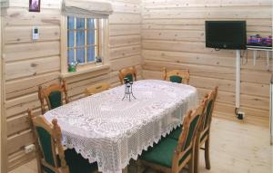 une salle à manger avec une table, des chaises et une télévision dans l'établissement Beautiful Home In Straumgjerde With 2 Bedrooms, à Ramstad