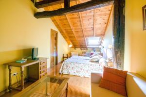 a bedroom with a bed and a desk with a television at Hotel Palacio Garcia Quijano in Los Corrales de Buelna