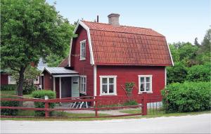 uma casa vermelha com um telhado vermelho e uma cerca em Lovely Home In Lrbro With Kitchen em Kappelshamn