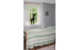 a bedroom with a bed with a cat in the window at Holiday Home Lärbro 33 in Kappelshamn +3 photos