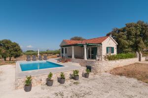 eine Villa mit einem Pool und einem Haus in der Unterkunft Holiday home Blato in Postira
