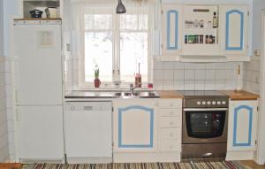 uma cozinha com armários azuis e brancos e um lavatório em Cozy Home In Marieholms Bruk With Kitchen em Marieholm