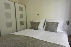 a white bed with two pillows on top of it at Aparthotel Stoll in Bad Soden am Taunus