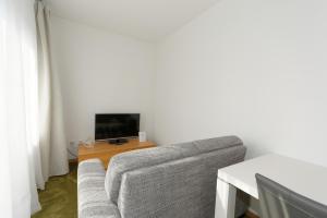 a living room with a couch and a tv at Aparthotel Stoll in Bad Soden am Taunus