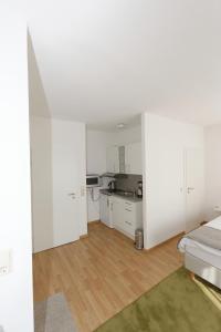 a white room with a bed and a kitchen at Aparthotel Stoll in Bad Soden am Taunus