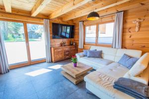 a living room with a white couch and a tv at Chalet Huber by Alpenidyll Apartments in Aich