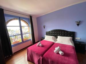 a bedroom with a bed with two white crosses on it at Hotel Alkhalifa in Chefchaouen