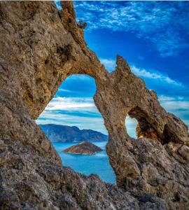 an arch in the rocks near the ocean at Manolakis Pizanias in Emborios