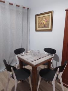 a dining room table with four chairs and a painting at Manolakis Pizanias in Emborios
