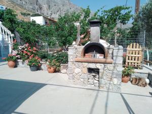 a stone oven sitting on a sidewalk with flowers at Manolakis Pizanias in Emborios