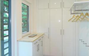 a kitchen with white cabinets and a window at Haus 5 in Wendorf