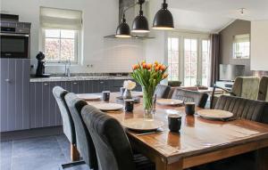 een keuken en eetkamer met een houten tafel en stoelen bij Buitengoed Het Lageveld - 108 in Hoge-Hexel